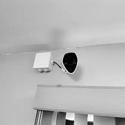 Cámara de seguridad instalada en un muro exterior con su caja de conexiones