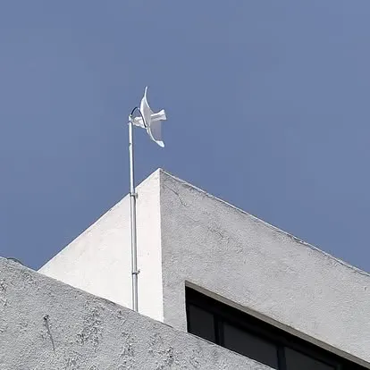 Antena de enlace inalámbrico montada en un mástil sobre un edificio